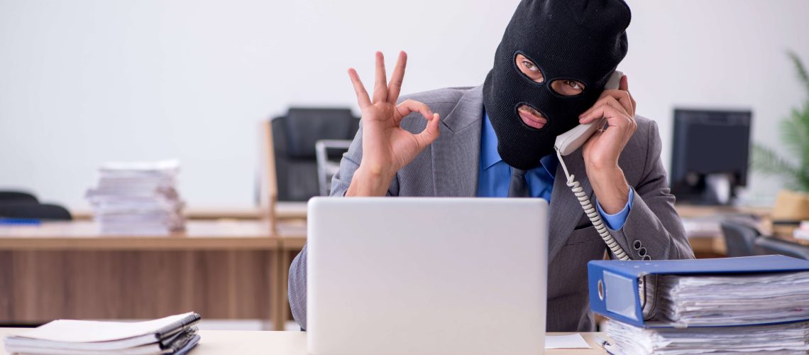 Young employee in industrial espionage concept